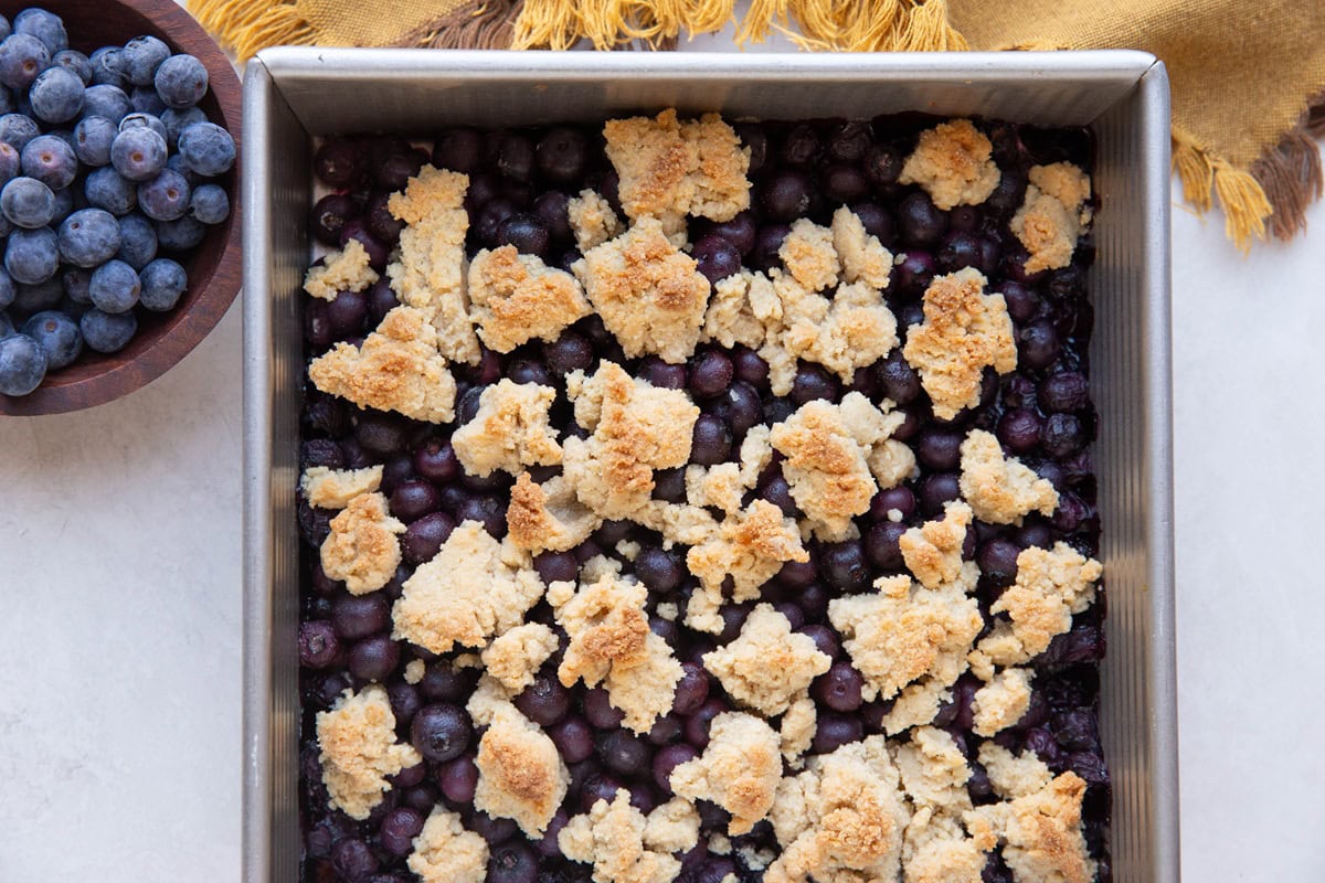 Baking dish with blueberry filling and almond flour topping.