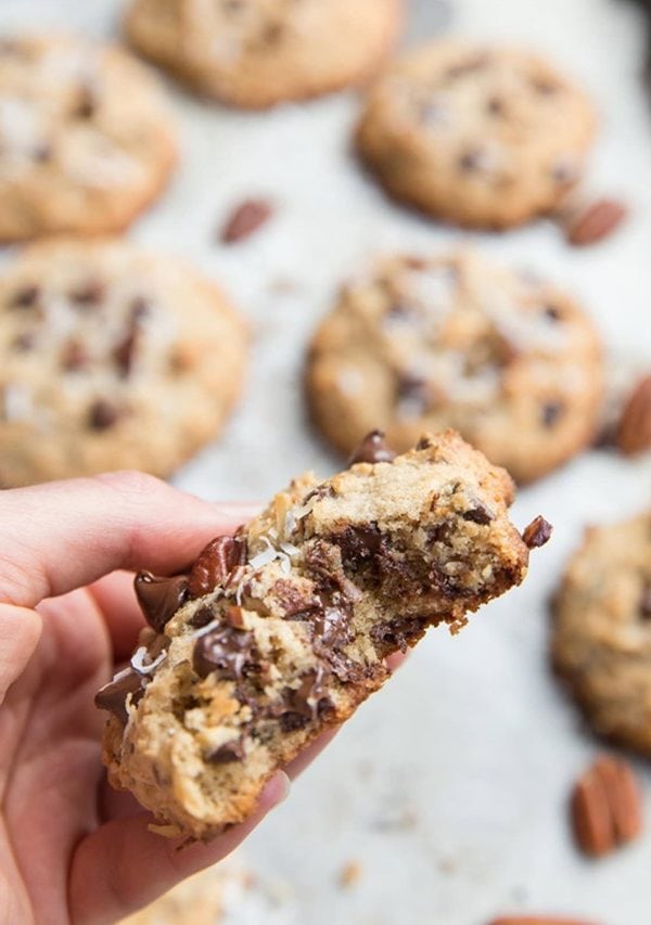 Hand holding a gooey cookie with a bite taken out.