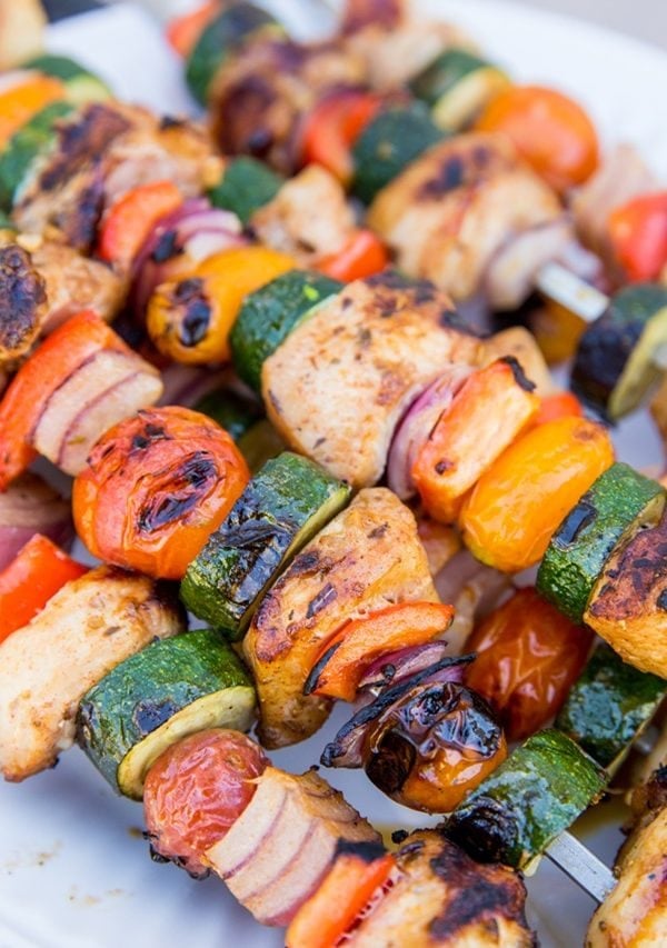 Grilled chicken skewers on a plate, ready to be served.