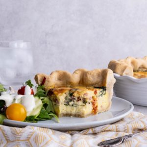 Slice of quiche with a bite taken out.