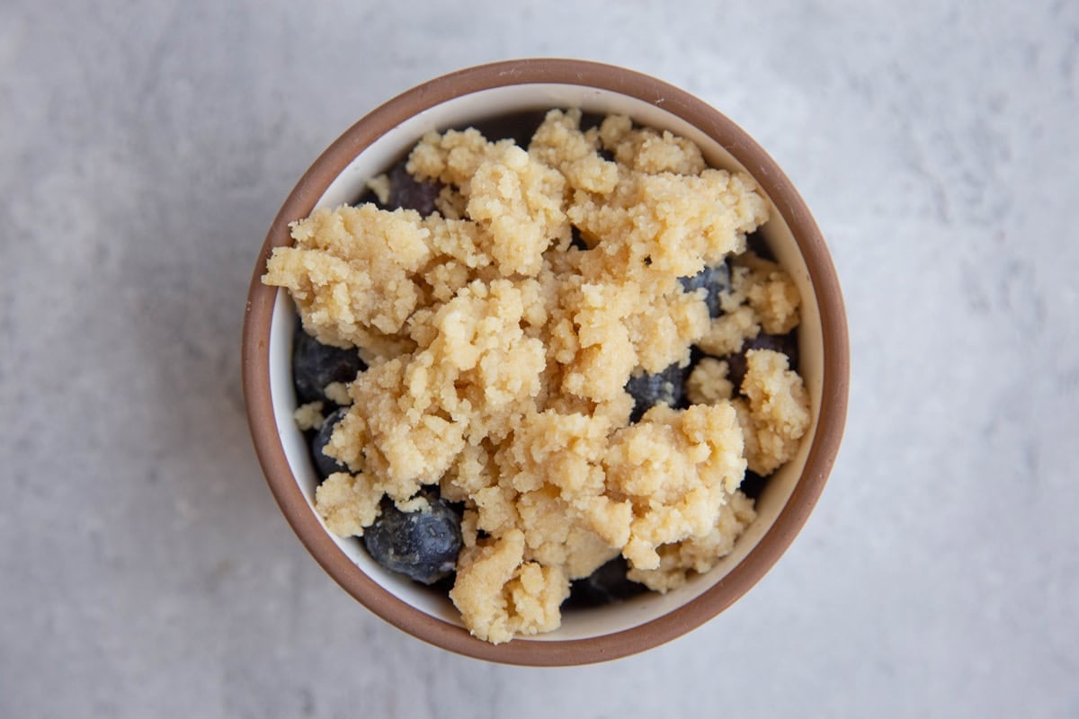 Ramekin with blueberries and crumble topping on top.