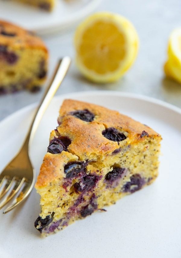 Almond flour lemon poppy seed cake slice on a plate, ready to eat.