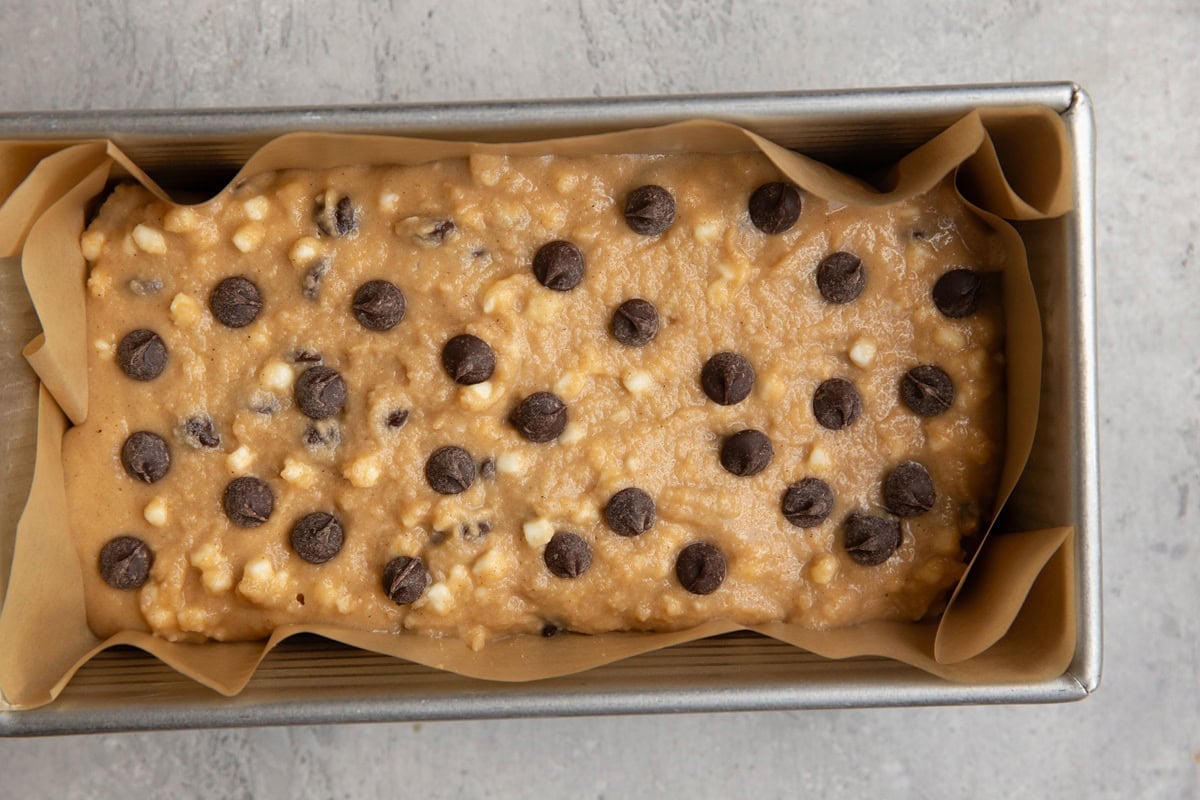 Loaf pan with chocolate chip bread batter inside, ready to go into the oven.