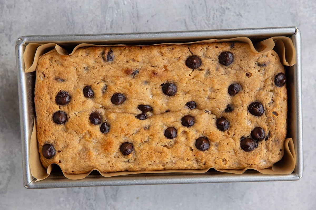 Loaf pan with chocolate chip bread inside.