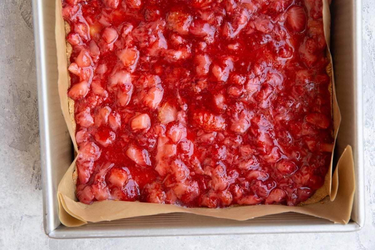 Baking pan with strawberry filling on top of shortbread crust.