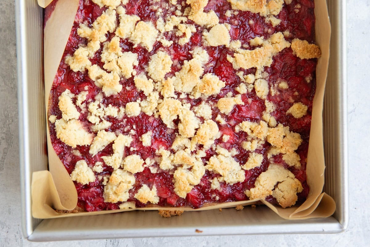 Strawberry crumb bars in a baking dish, fresh out of the oven. Ready to be cut into individual slices.