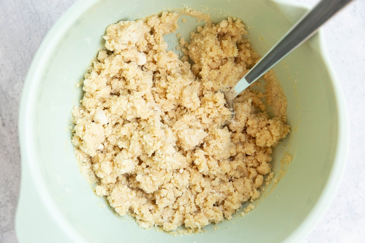 Mixing bowl full of almond flour crust mixture to make strawberry pie bars.