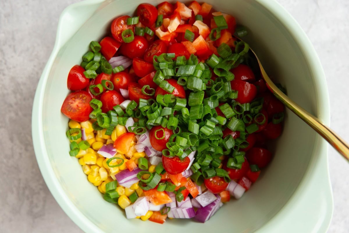 Mixing bowl full of ingredients for black bean salad