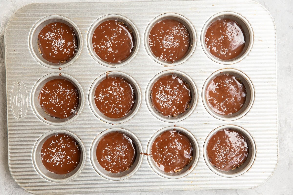 Melted chocolate over a layer of energy bite ingredients.