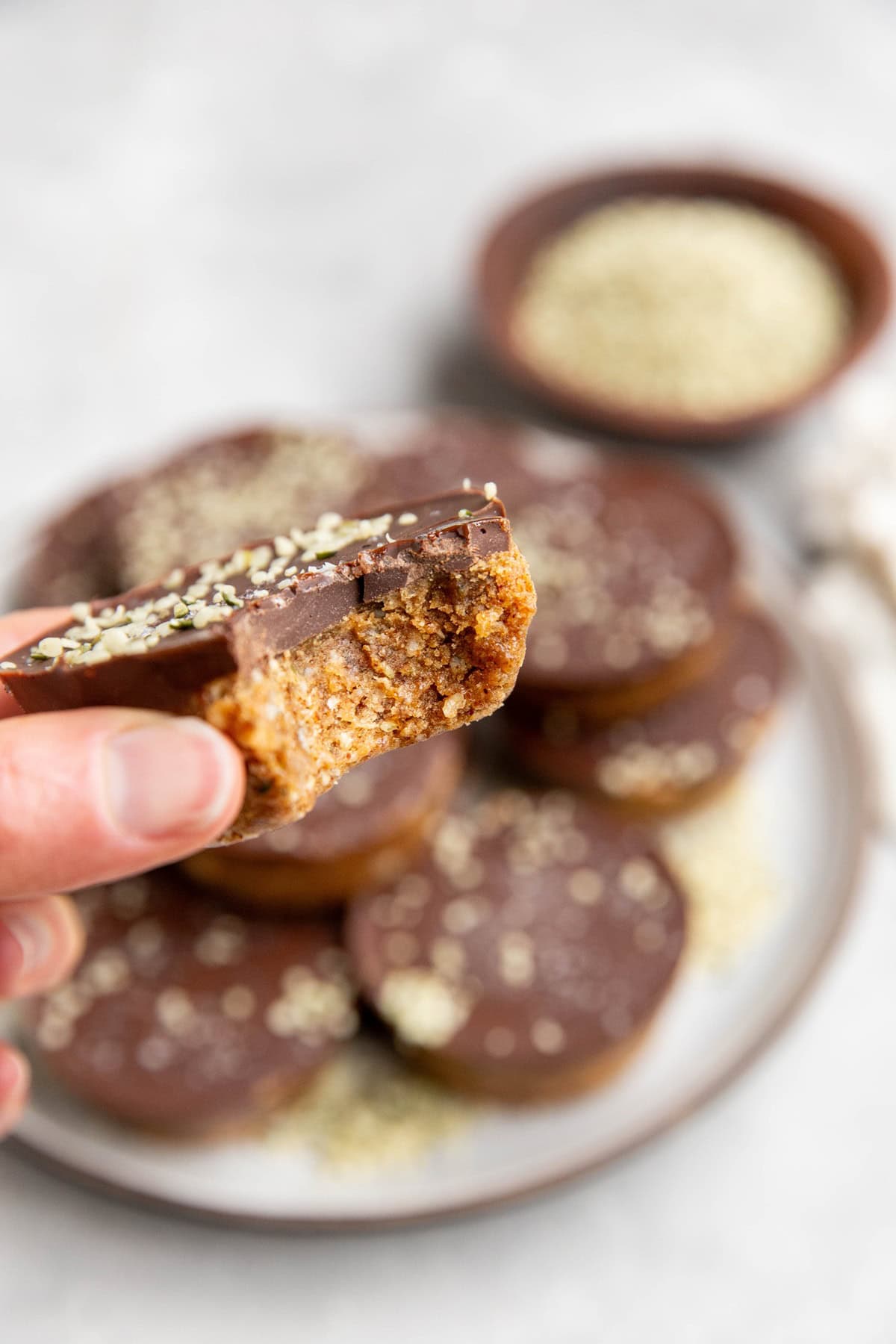 Hand holding a chocolate covered energy cup with a bite taken out.
