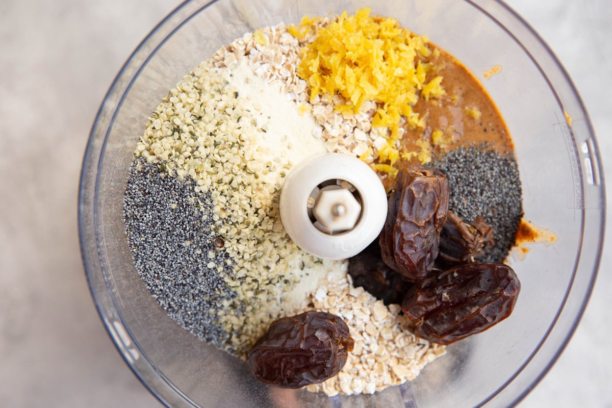 Ingredients for lemon poppy seed protein bites in a food processor, waiting to be processed.