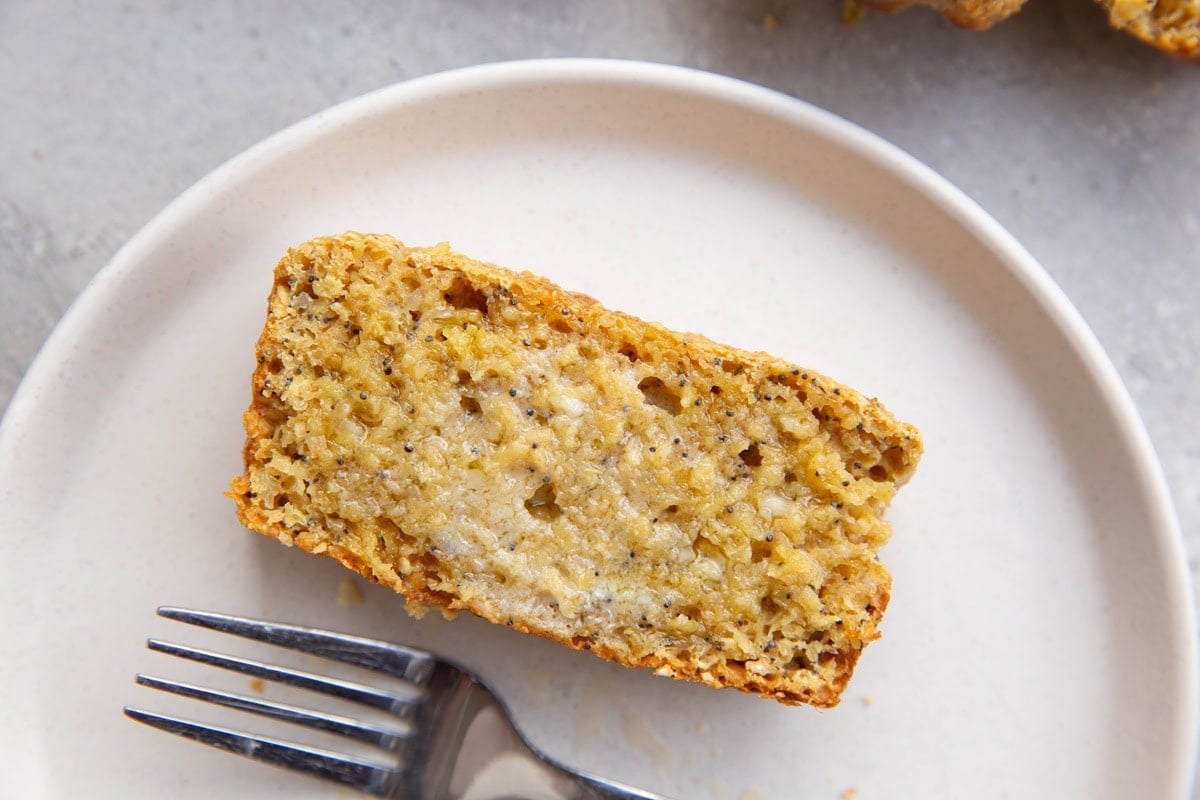 Slice of Lemon poppy seed bread on a plate with butter melted in.