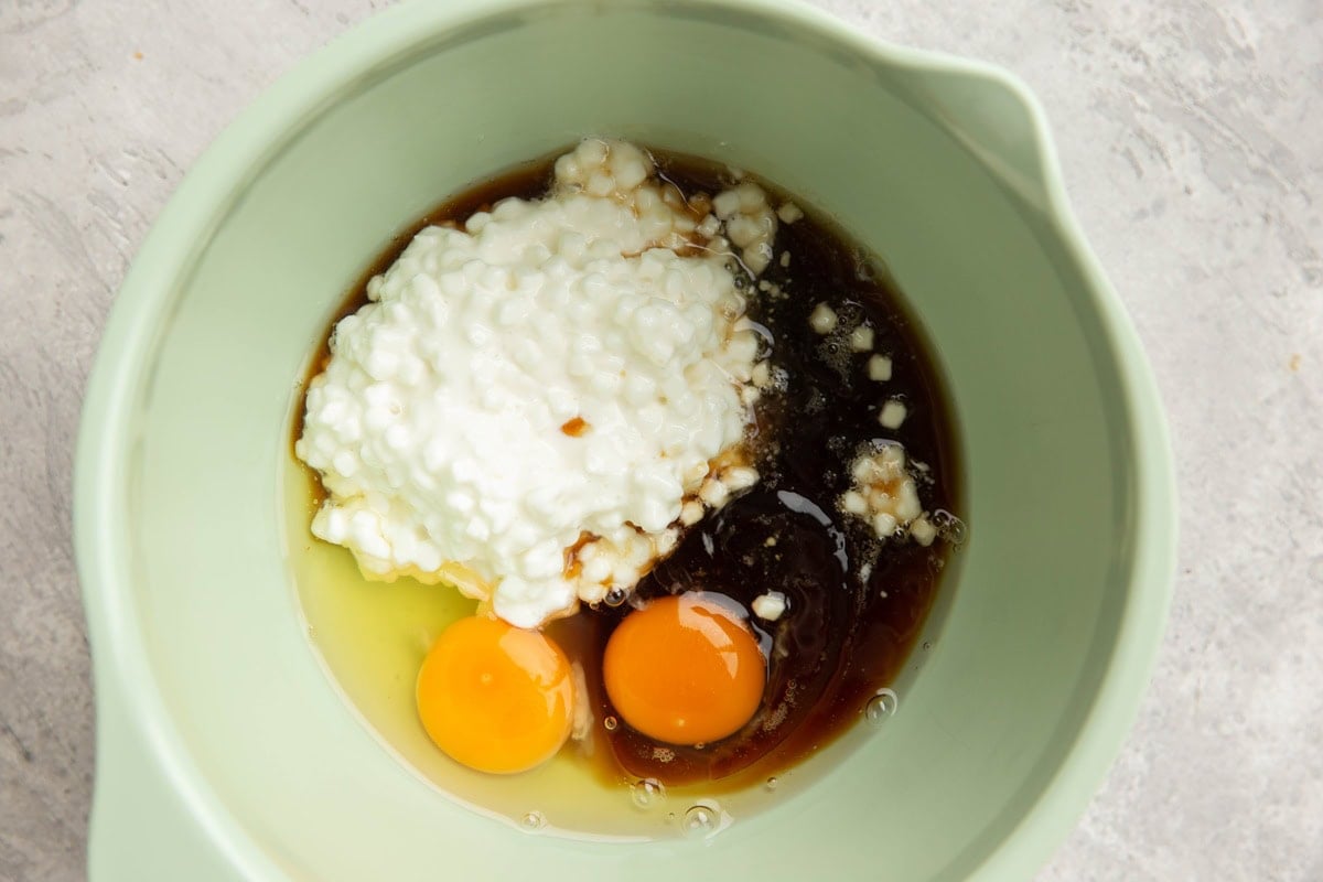 Cottage cheese, eggs, pure maple syrup in a large bowl, ready to be mixed for bread.