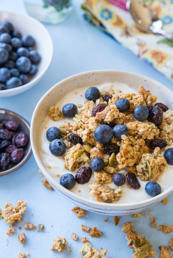 Big bowl of grain free granola on top of Greek yogurt with fresh berries.