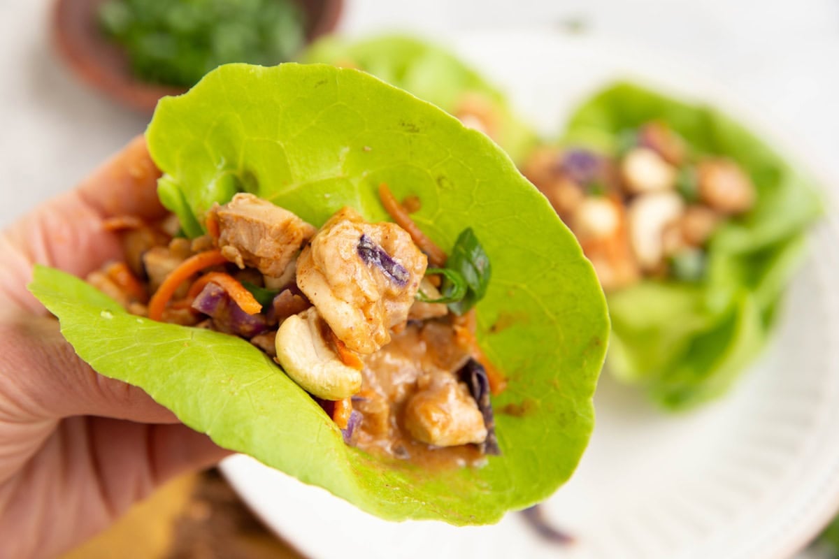 Thai Chicken Lettuce Cup in a hand, ready to be eaten.