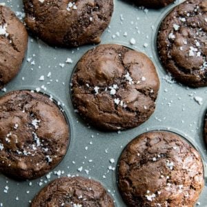 Almond Flour Chocolate Zucchini Muffins in a muffin tray, sprinkled with sea salt.