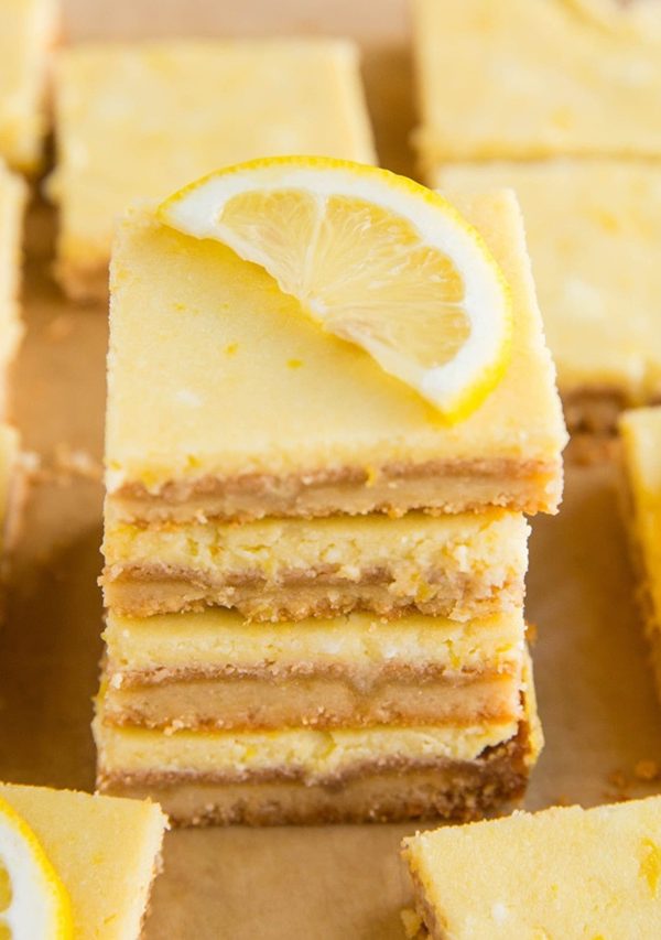Stack of gluten free lemon bars with a fresh slice of lemon on top.