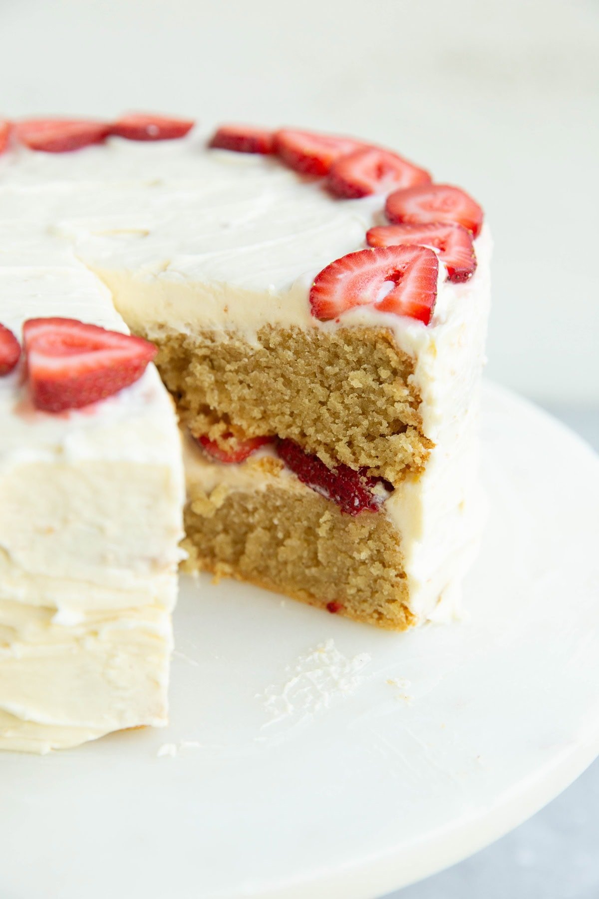Cake stand with vanilla layer cake with strawberry filling.