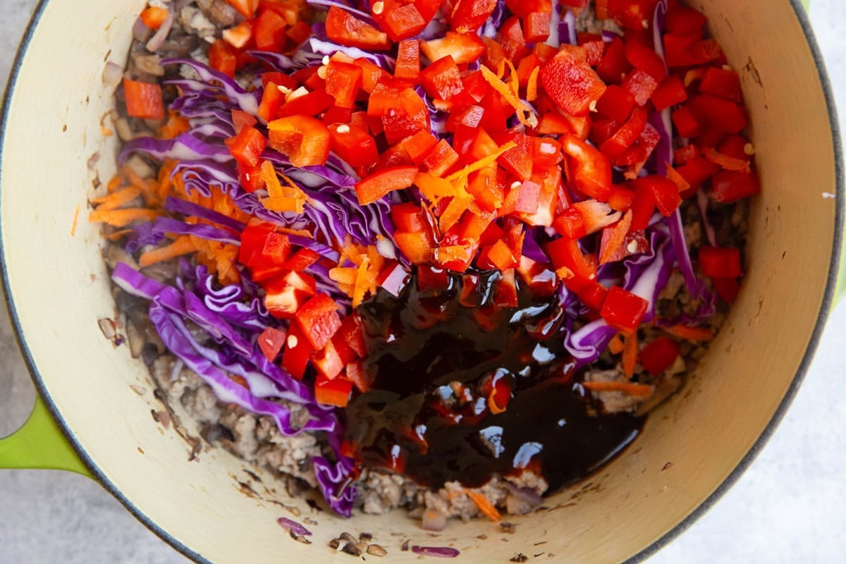 Large pot full of ground turkey and vegetables with hoisin sauce added in.
