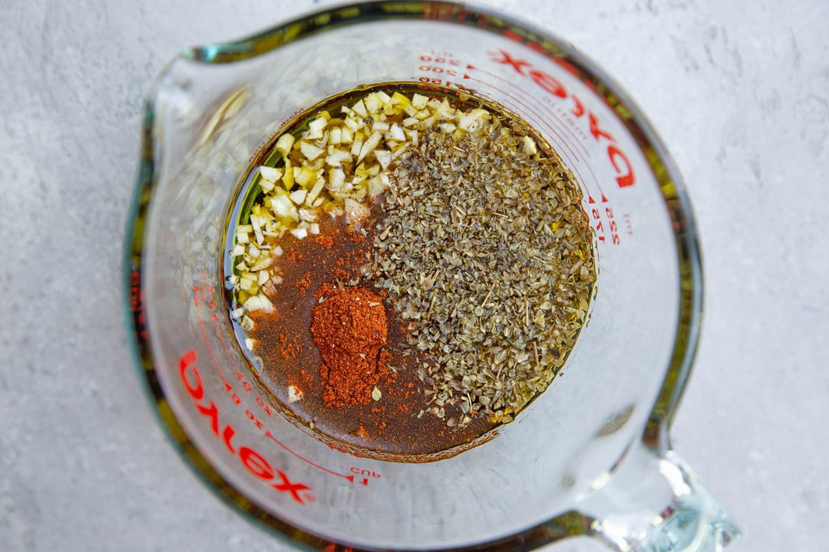 Measuring cup full of ingredients for chicken drumstick marinade. Ready to be mixed together to marinate chicken.