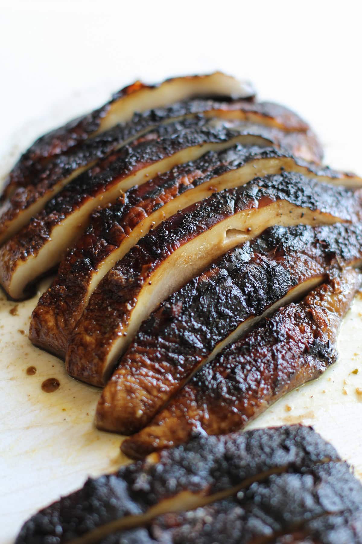 Portobello mushroom on a cutting board, cut into slices.