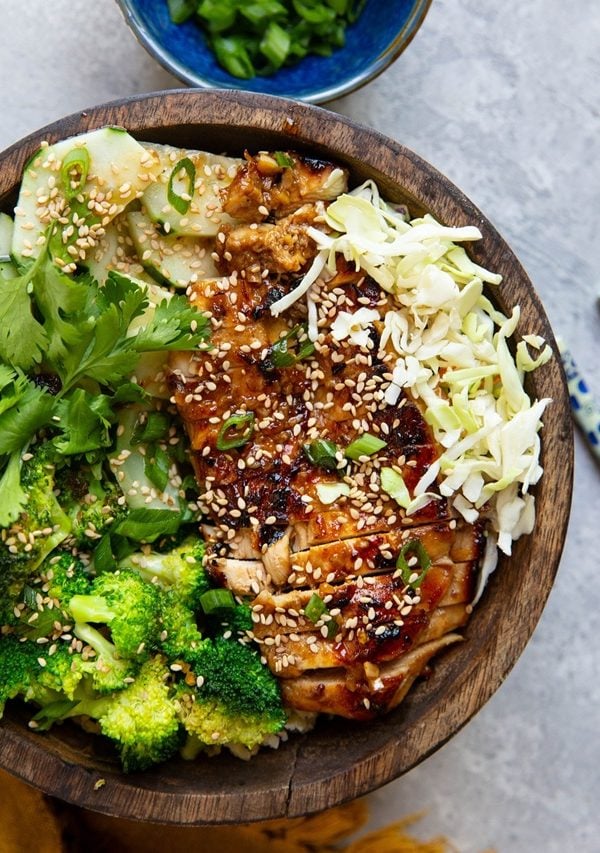 Large bowl of Korean BBQ Chicken with fresh veggies and rice.