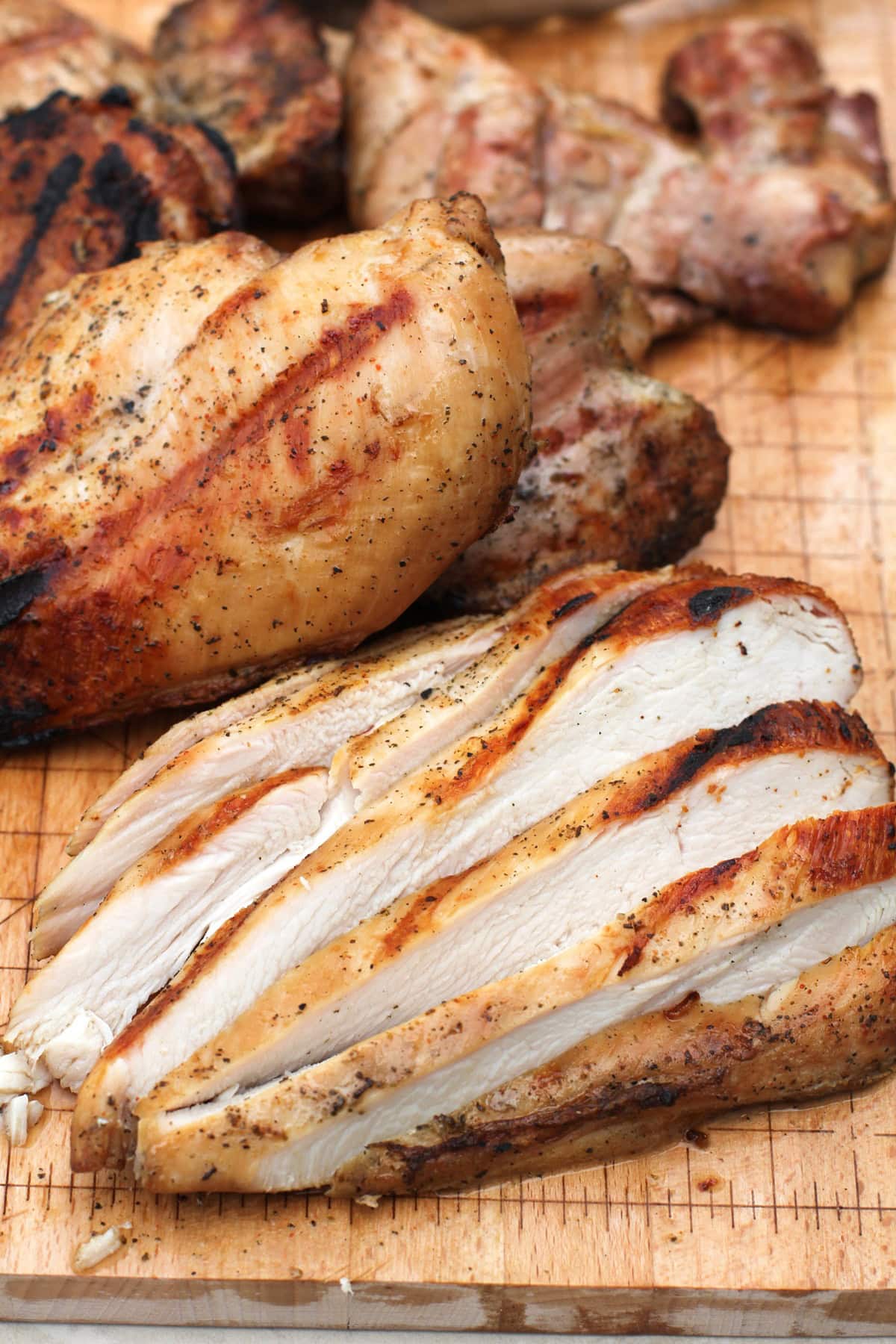 Sliced grilled chicken breast on a cutting board, ready to serve,