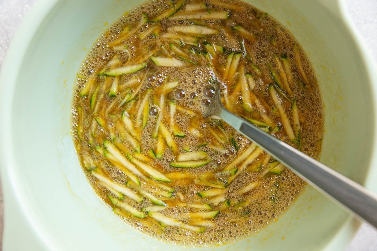 Mixing bowl with wet ingredients for zucchini bread inside.