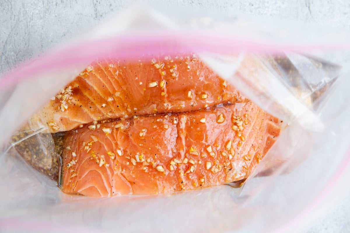 Salmon marinating in a large zip lock bag with balsamic marinade.