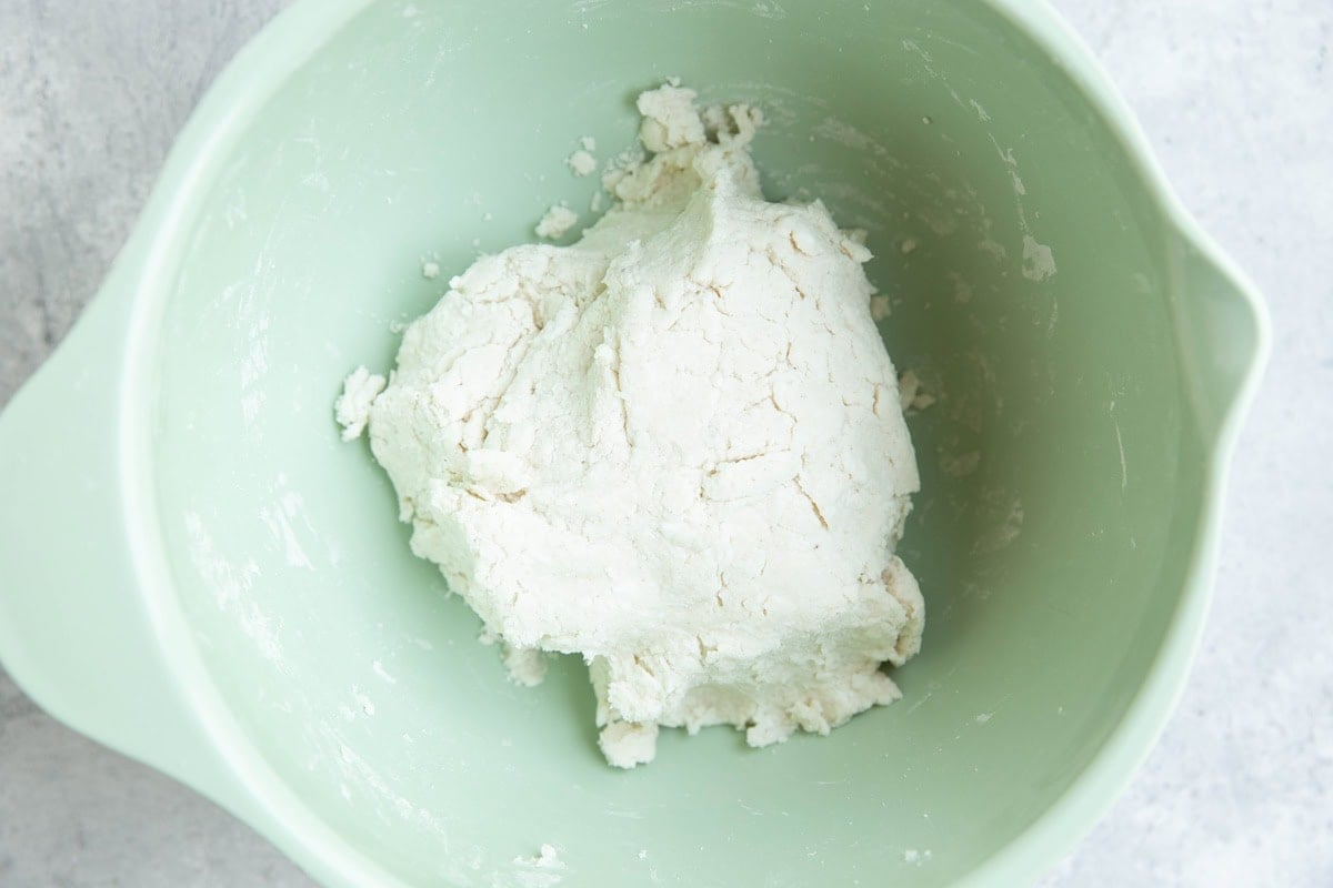 Big ball of dough in a mixing bowl, ready to be turned into bagels.