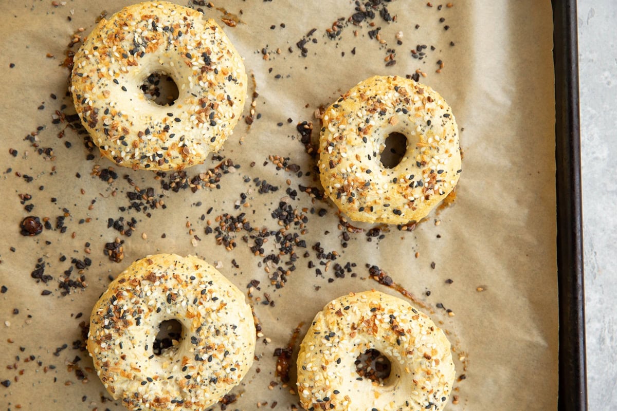 Baking dish with four everything bagels on top, ready to eat.