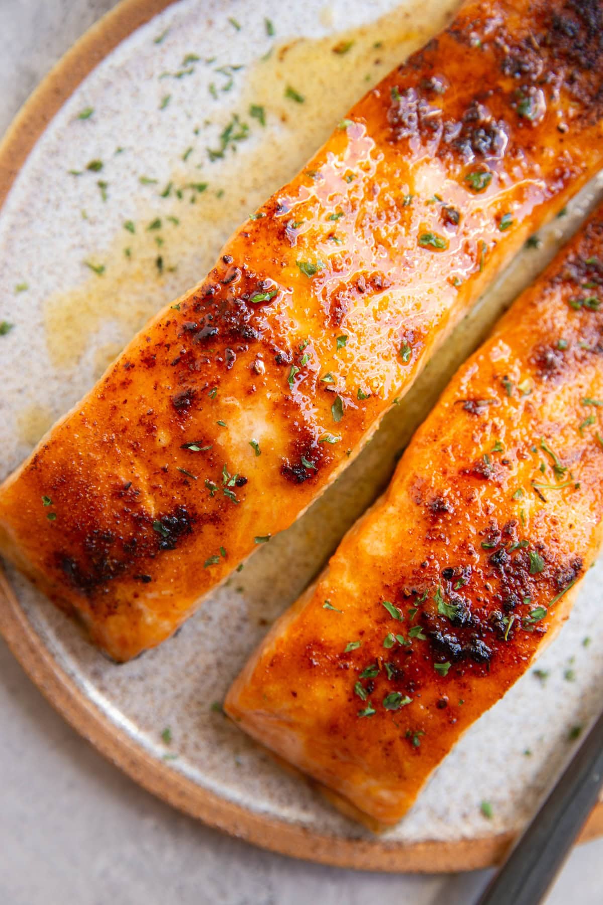 Two large salmon filets on a plate drizzled with honey.