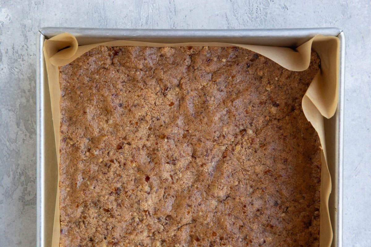 Square baking pan with cookie dough mixture pressed inside to make protein bars.