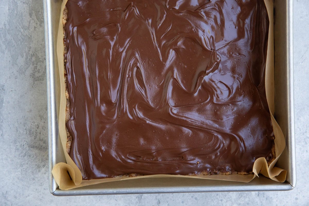 Pan full of cookie dough protein bars with melted chocolate layer on top