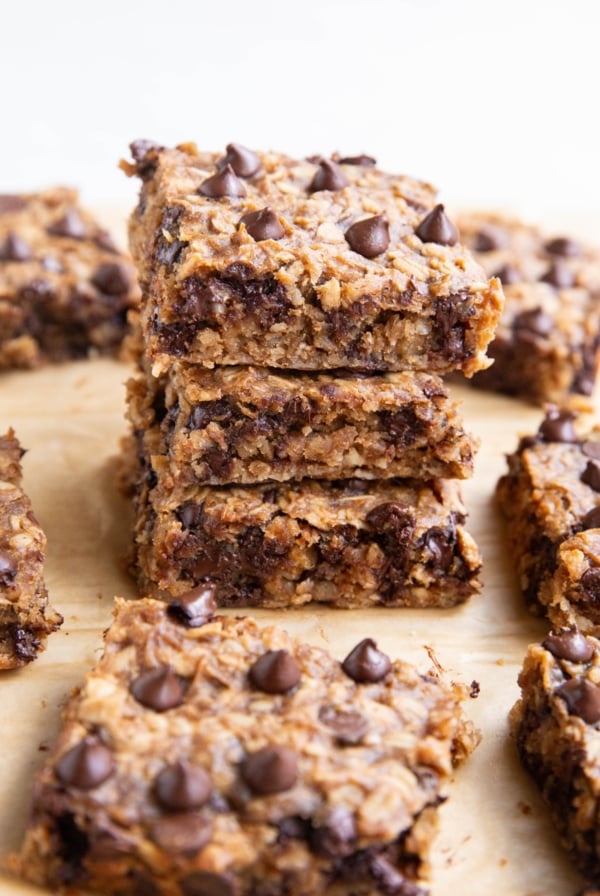 Stack of oatmeal protein bars with many bars all around.
