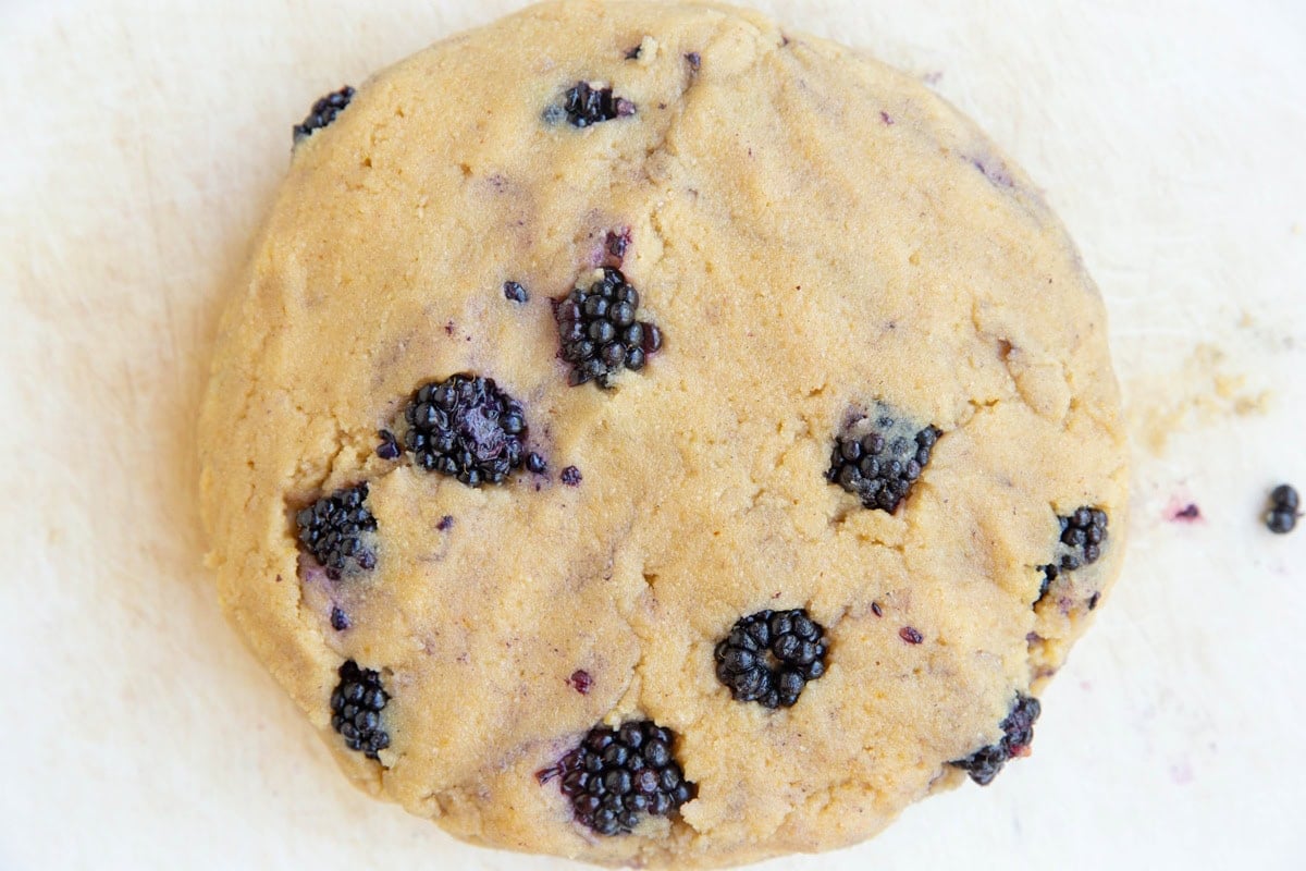 Disc of scone dough on a cutting board.