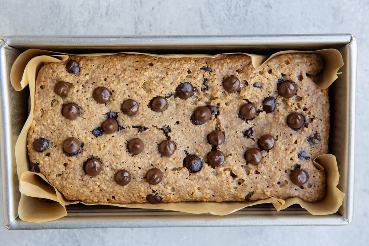 Chocolate chip oatmeal bread in a loaf pan, fresh out of the oven.