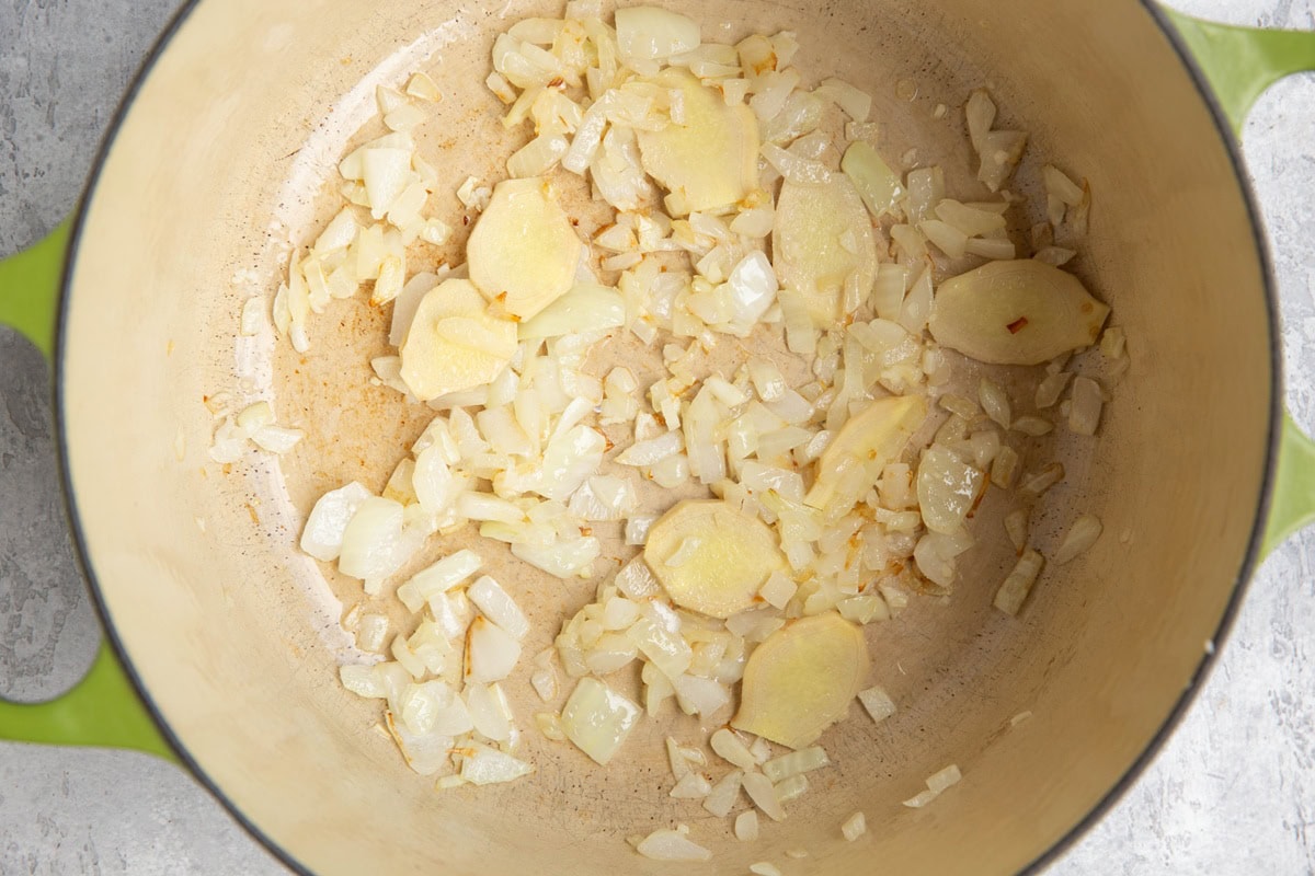 Onion, garlic, and ginger sautéing in a large pot.