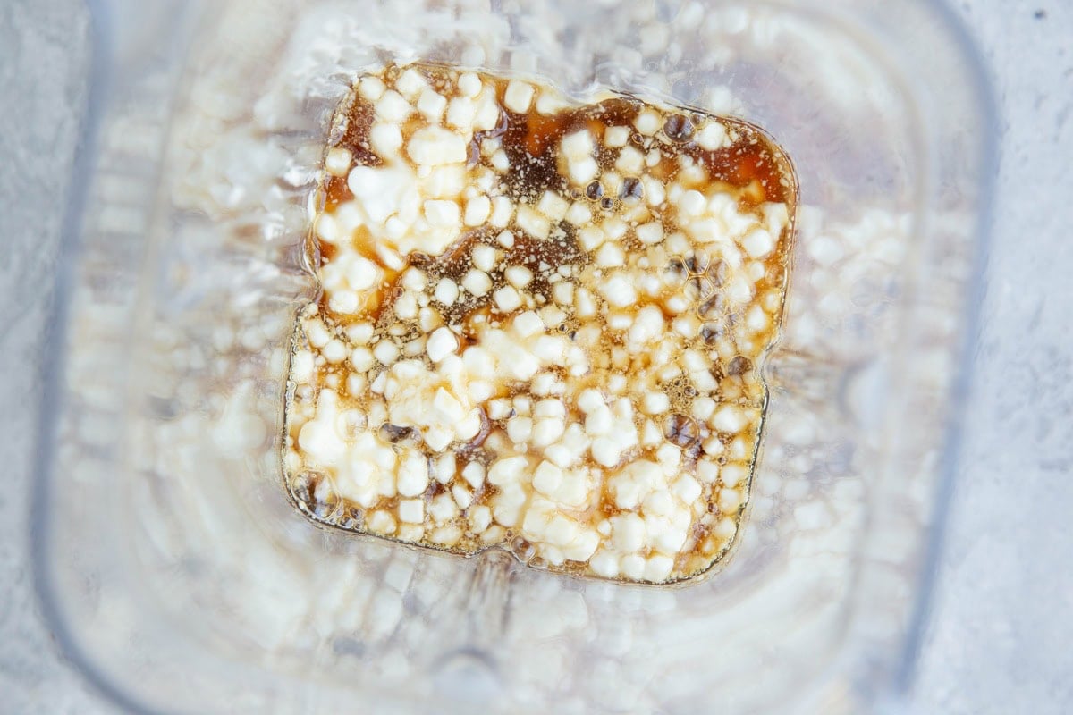 Cottage cheese, pure maple syrup, and almond butter in a blender, to be blended for brownies.