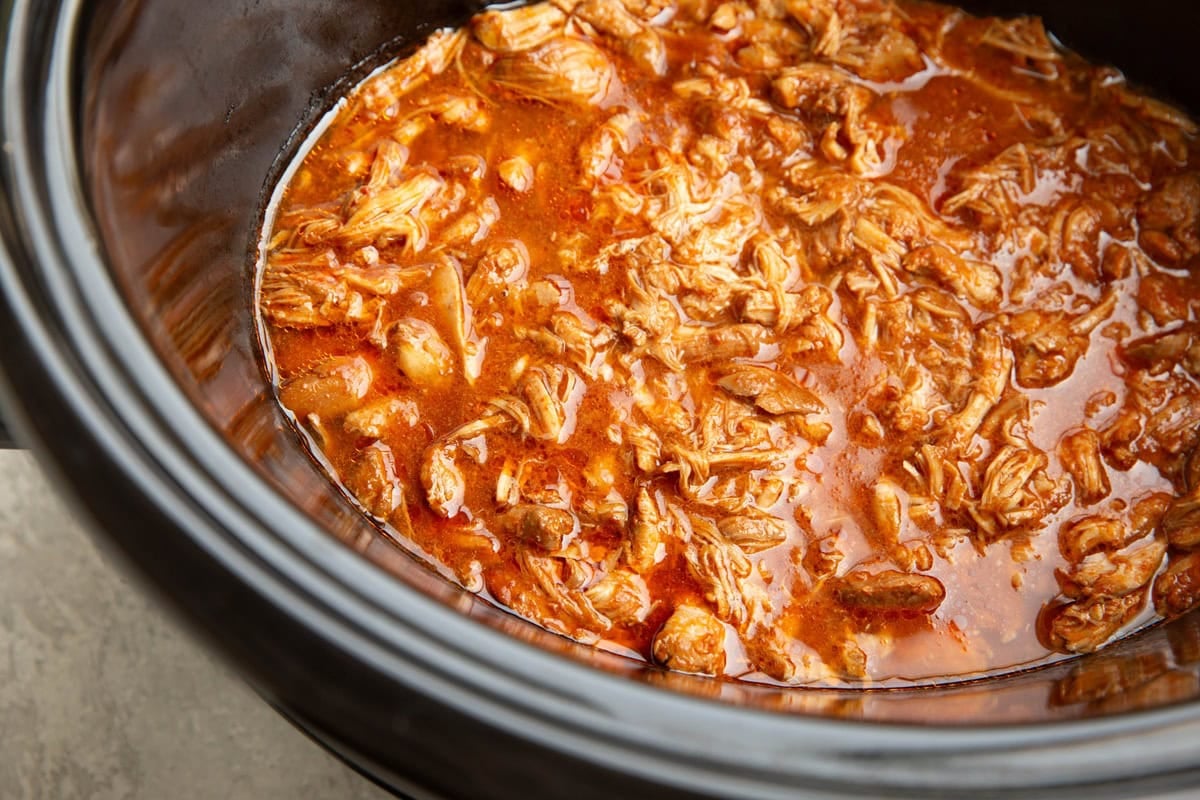 Shredded birria chicken in a slow cooker.