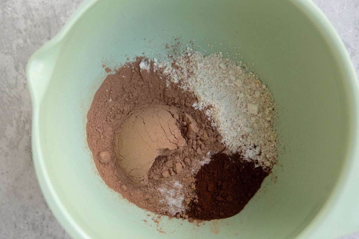Cocoa powder, oat flour, salt, and instant coffee granules in a mixing bowl.