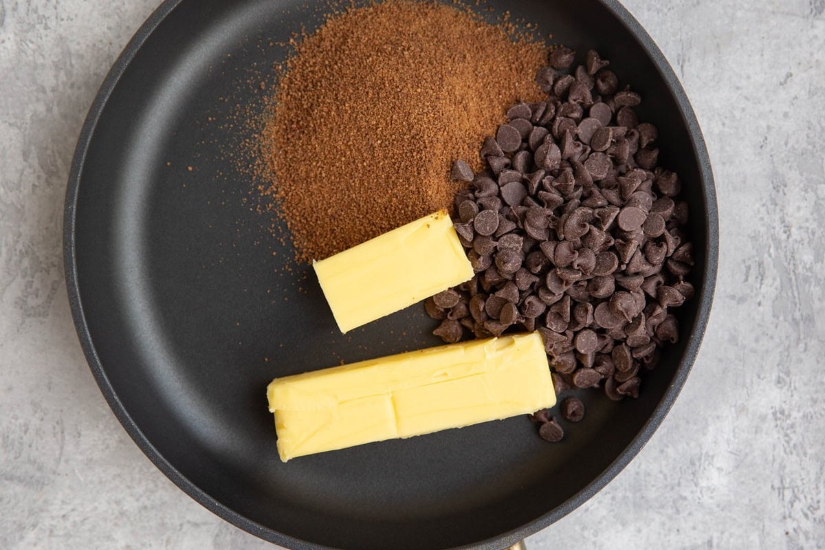 Butter, sugar, and chocolate chips in a skillet, to be melted.