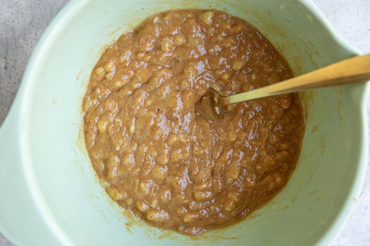 Mashed bananas and peanut butter mixed in a mixing bowl.