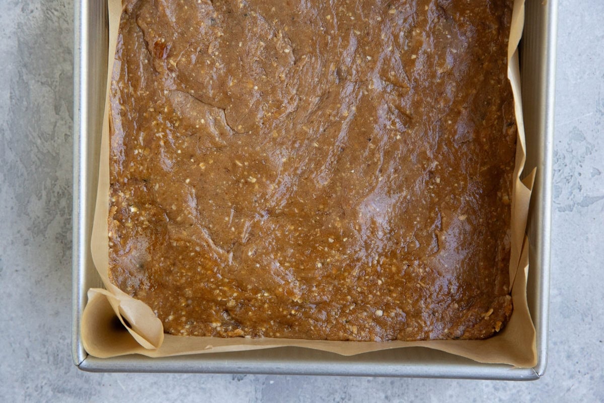 Baking pan with peanut butter mixture pressed inside to make peanut butter protein bars.