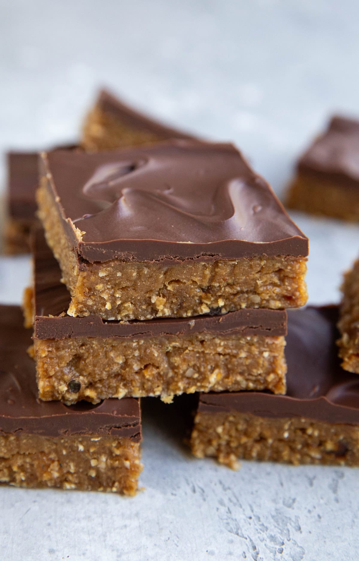Peanut Butter protein bars stacked on top of one another with a chocolate layer on top. Ready to eat.