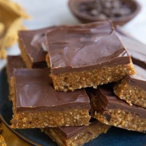 Plate of protein bars with a bowl of chocolate chips in the background.