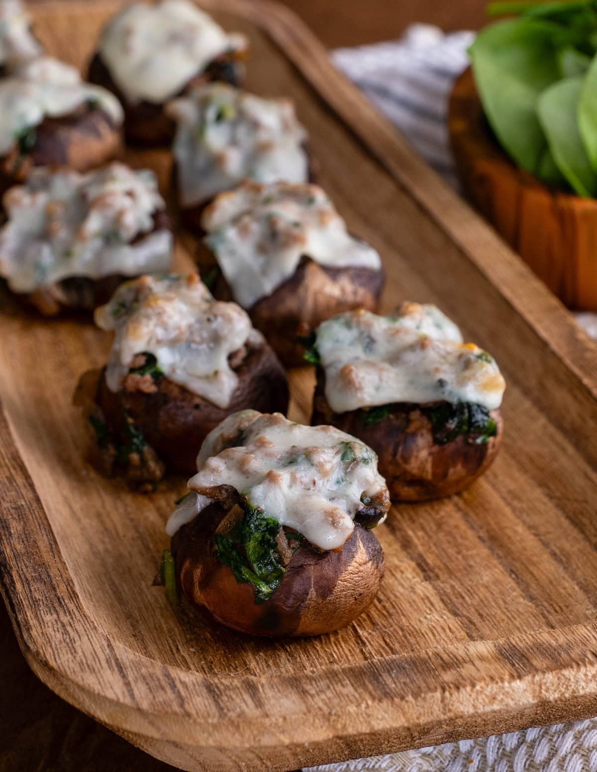 Stuffed mushrooms on a wooden platter, ready to serve.