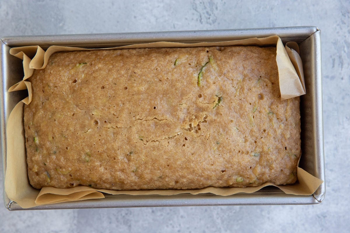 Loaf of zucchini bread in a bread pan, fresh out of the oven.