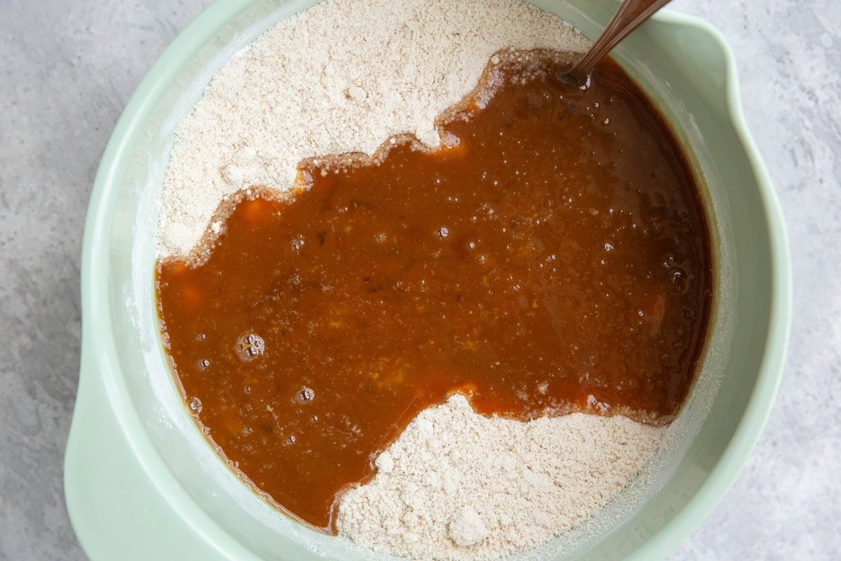 Mixing bowl of dry ingredients with wet ingredients being mixed in.