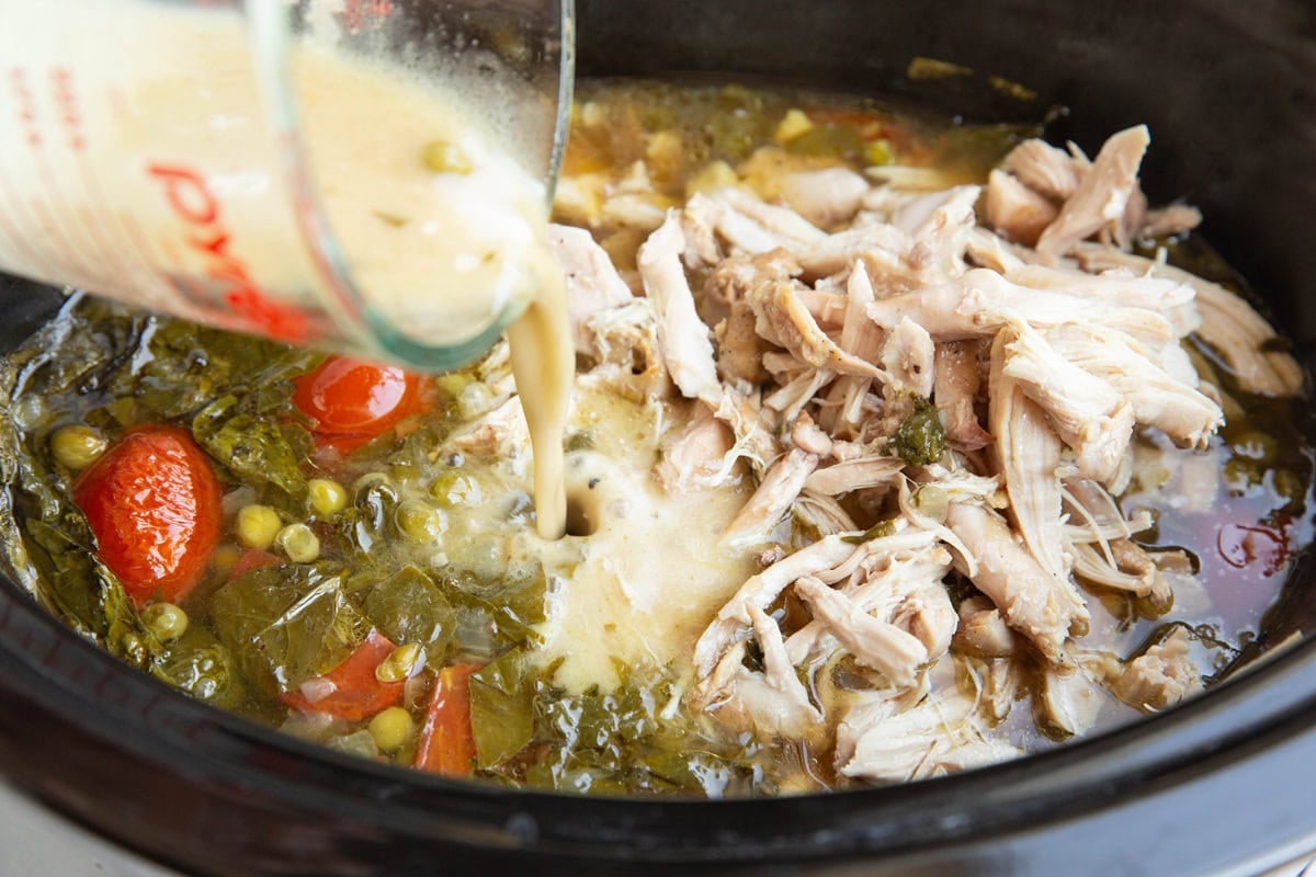 Pouring broth mixed with flour into the crock pot to thicken the stew.